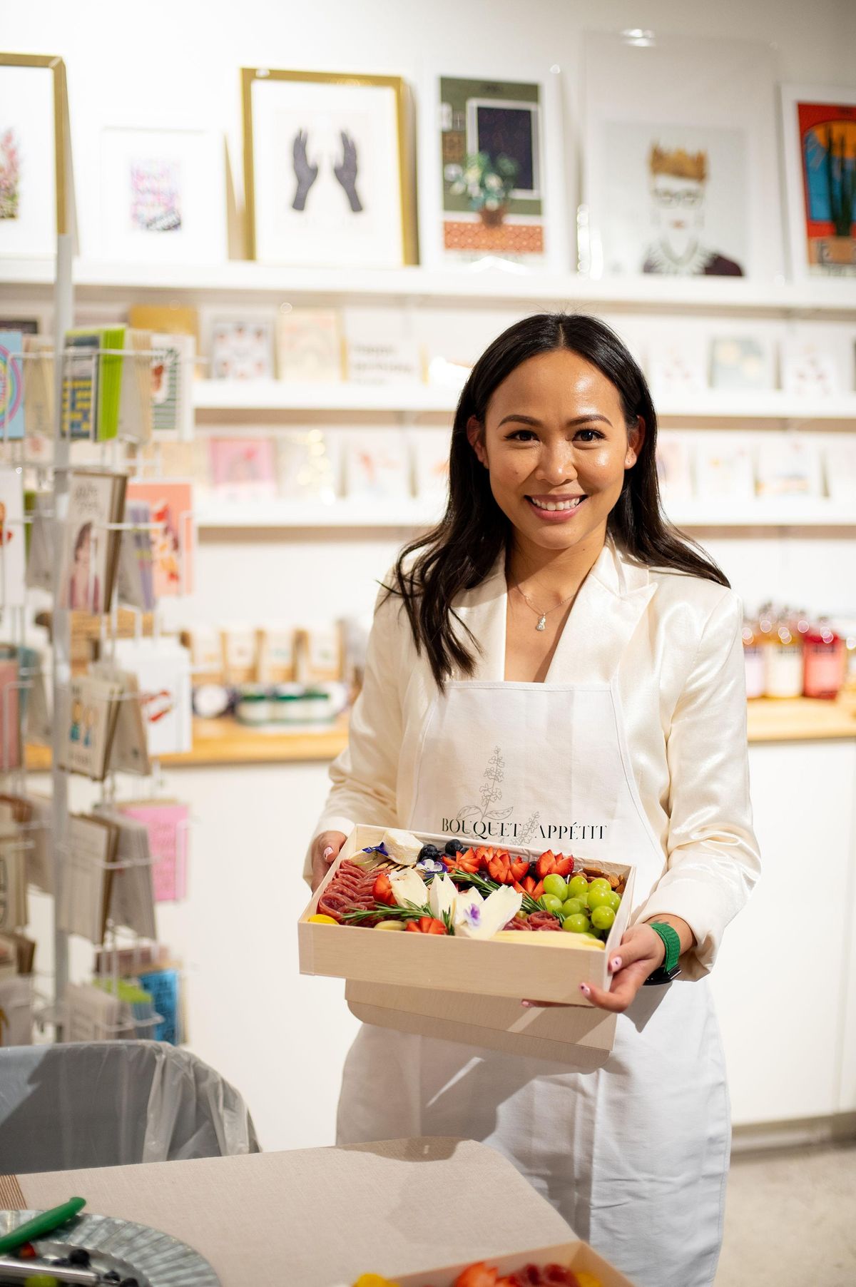 Alecia Huynh displaying assembled charcuterie box in shop