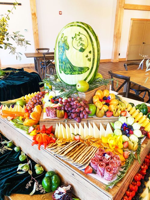 elaborate charcuterie display on table with fancy watermelon carving