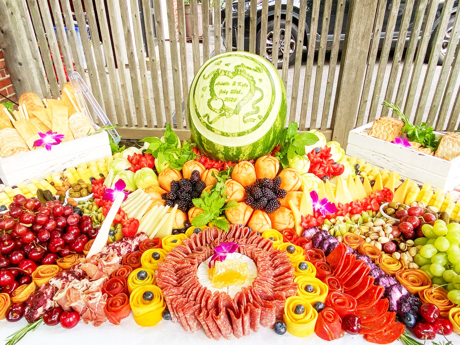 Fruit cheese and charcuterie grazing table with watermelon carving centerpiece